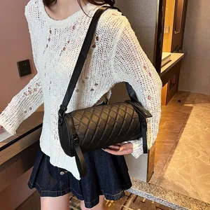 Black quilted cylinder shoulder bag with diamond stitching and adjustable strap for women
