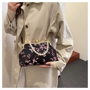 Detail of vintage Chinese style bag with cherry blossom embroidery and pearl clasp closure