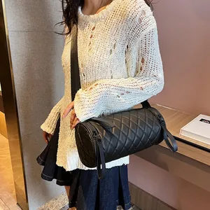 Quilted black cylinder crossbody bag with rhombic stitching and wide shoulder strap