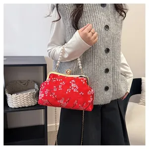 Detailansicht der roten Tasche mit Pflaumenblütenstickerei und Perlenhandgriff