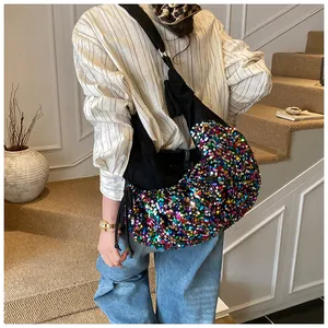 Detail of colorful sequins on a black crescent bag with wide shoulder strap