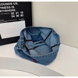 Detailed interior view of blue denim handbag showing zipper closure and spacious capacity