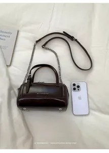 Vue détaillée du mini sac Boston marron foncé avec détails en métal argenté