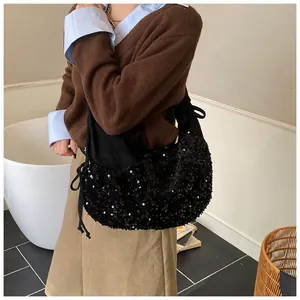 Detail of shimmering black sequins and side drawstring on large crescent shoulder bag