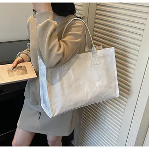 Detail of white Tyvek tote bag with embossed lettering and unique crinkled texture