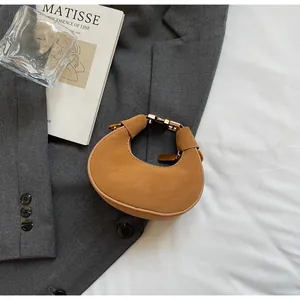 Détail du sac demi-lune camel en cuir mat avec des boucles métalliques dorées