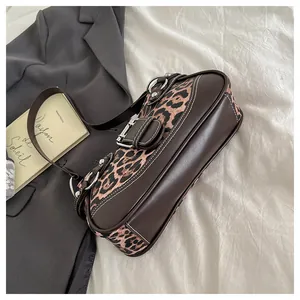 Detail of leopard print handbag featuring vintage buckles and contrast stitching accents