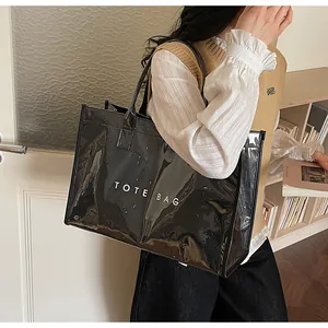 Glossy black tote bag featuring white TOTE BAG text print with spacious side design