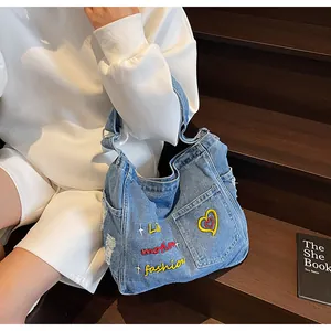 Detail showing vintage denim tote bag with colorful heart and letter embroidery