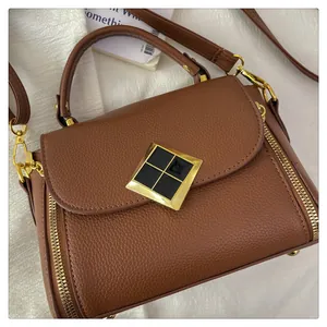 Vue détaillée du sac à main marron à motif litchi avec des accessoires en métal doré