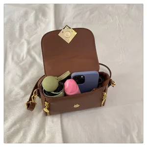 Vue intérieure du sac à main marron avec motif litchi montrant le rangement et les ferrures