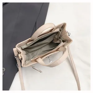 Vue de dessus d'un sac à main beige montrant les compartiments et la doublure à chevrons