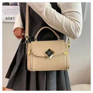 Détail du sac à main beige texture litchi avec ferrures dorées et fermeture éclair latérale