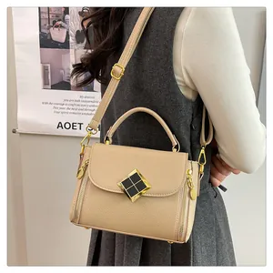 Détail du sac à main beige grainé avec fermoir doré et bandoulière réglable