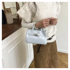 Gros plan du sac à main bleu clair avec boucle en cuir et doubles poignées au quotidien