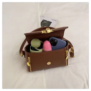 Vue détaillée de l'intérieur du sac en cuir marron avec téléphone et cosmétiques