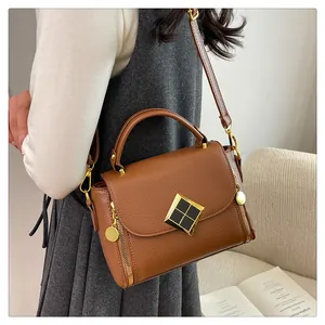 Sac à main marron motif litchi avec ferrures dorées et fermoir pivotant élégant