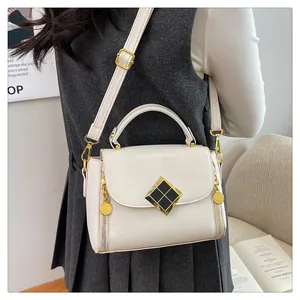 Détail du sac à main en cuir blanc cassé à motif litchi avec fermoir en métal doré