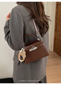 Detail shot of brown crocodile texture leather and silver clasp on the crossbody bag