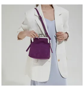 Détail du sac vintage violet foncé avec fermoir à baiser et cadre métallique chic