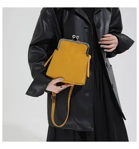 Détail du sac coquillage jaune avec fermoir métallique argenté et bandoulière en cuir