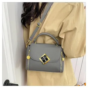 Détail du sac à bandoulière gris texturé avec ferrures dorées et fermoir en losange