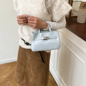 Mini sac à main en cuir verni bleu clair avec fermoir argenté et sangle décorative