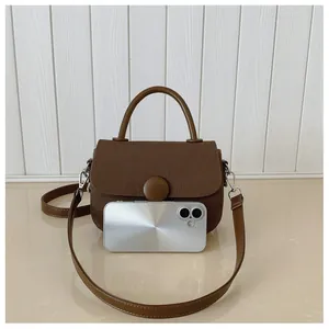 Vue détaillée d'un sac à main en toile marron foncé avec boucle ronde et smartphone