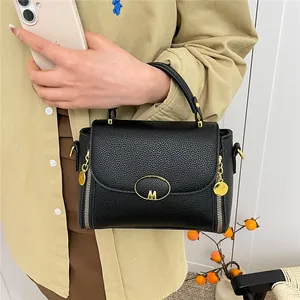 Sac à main chic noir motif litchi avec logo M doré et détails de fermeture éclair