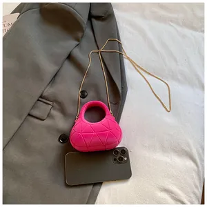 Detail of rose pink mini chain bag with geometric texture on grey blazer
