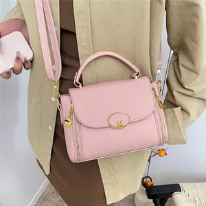 Sac à main rose texture litchi avec boucle logo M dorée et bandoulière amovible