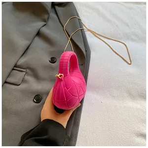Macro shot of fuchsia quilted mini bag with gold chain strap held against grey blazer