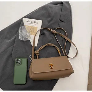Detail of lychee textured leather bag with gold rectangular twist lock in khaki