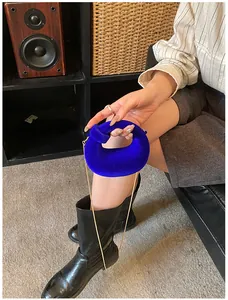 Detail of royal blue velvet donut bag with golden chain on a vintage leather sofa