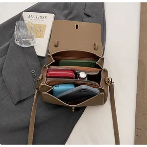 Overhead view showing three internal compartments of a khaki lychee pattern handbag