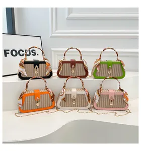 Detail showing colorful woven straw crossbody bags with silk scarf handles and chain straps