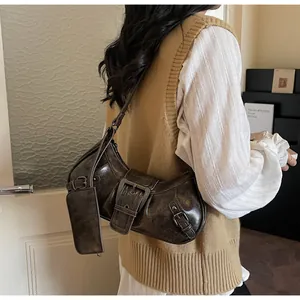 Detail of dark brown retro underarm bag with oversized buckle and small pouch