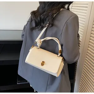 Back view of model wearing white litchi pattern leather bag with knotted top handle