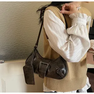 Detail of vintage brown underarm bag with large metal buckle and crackle texture leather