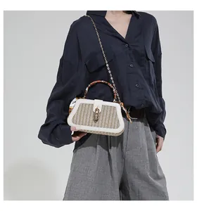 Macro view of retro woven handbag with white leather trim and decorative silk scarf detail