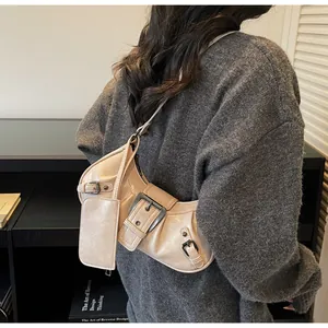 Close-up of beige biker-style shoulder bag with metal buckles and mini purse attachment
