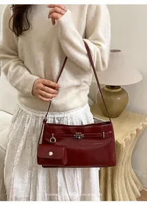 Chic burgundy underarm bag in shiny patent leather with a small matching pouch pendant