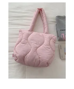 Detail view of the pink quilted puffer bag with chic wave pattern and fashion tag