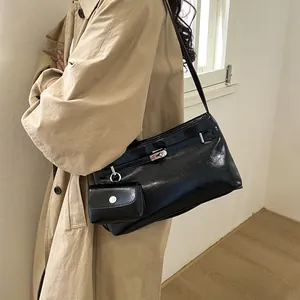 Glossy black underarm bag with silver buckle and mini pouch shown on a model