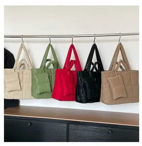 Sacs cabas matelassés en cinq couleurs avec mini pochettes assorties sur un support