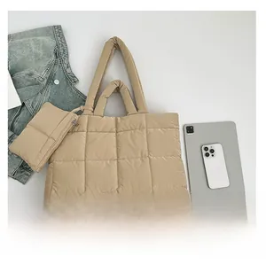 Vue à plat du sac cabas matelassé beige avec petit porte-monnaie et accessoires