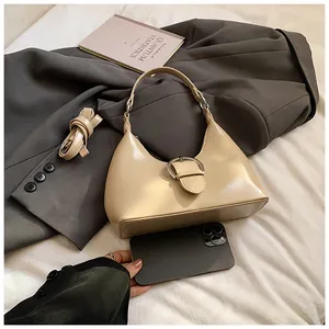 Détail d'un sac à main demi-lune crème avec boucle argentée et bandoulière réglable