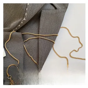 Macro detail of glossy golden crescent handle and sparkling sequin evening bag fabric