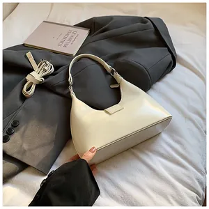 Détail latéral du sac hobo en similicuir crème avec bandoulière réglable amovible