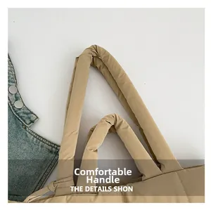 Détail de la poignée rembourrée et de la texture en nylon matelassé du sac cabas